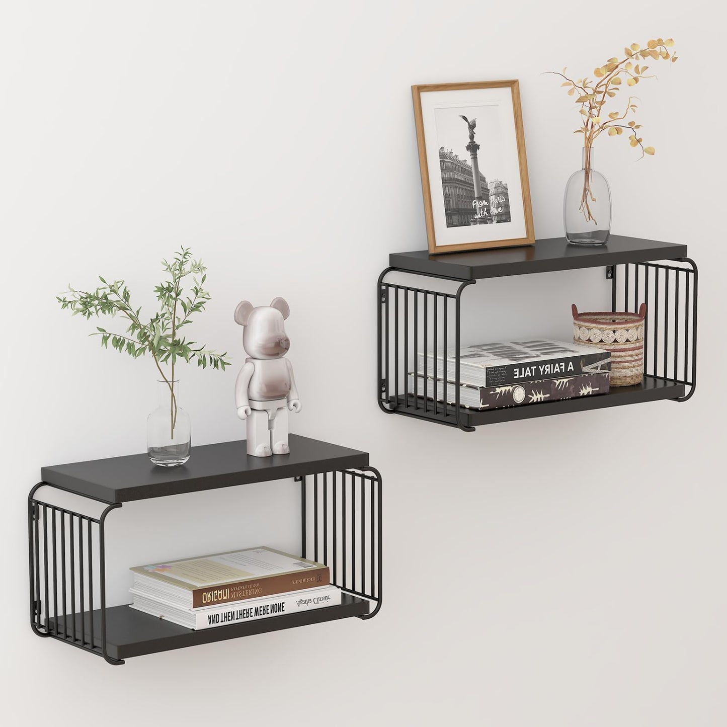 Two black metal wall shelves with books, a plant, and decorative items on a white wall.