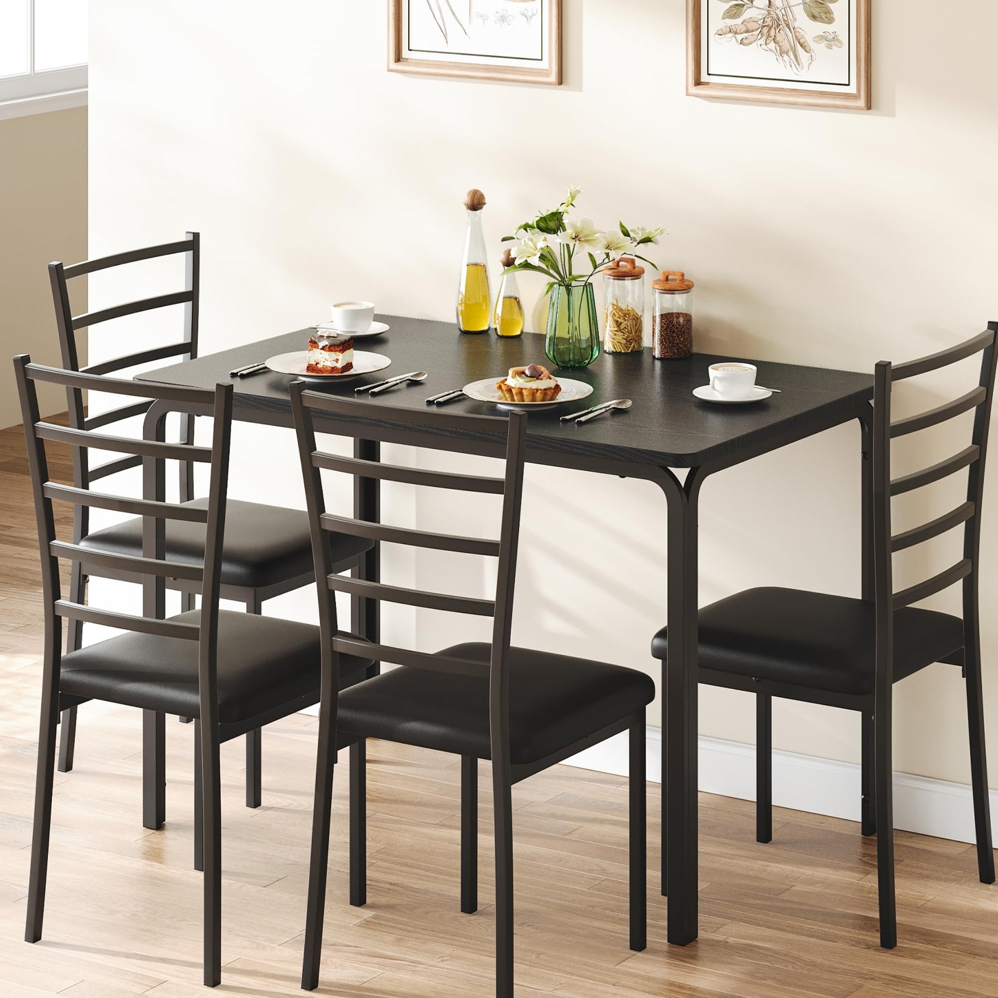 Dining table set with four chairs in a room with framed pictures on the wall.