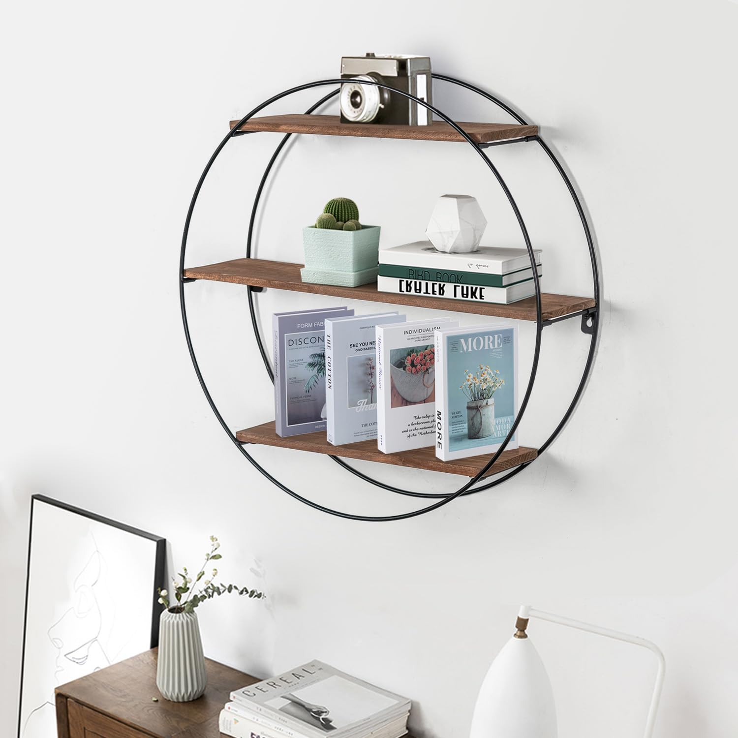 Round wall shelf with books and decor items on a white wall