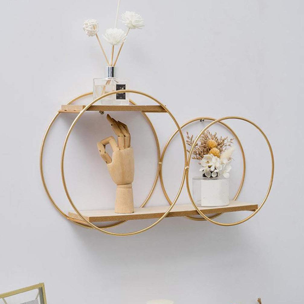 Decorative wall shelf with gold circular design and small plants on a light gray background