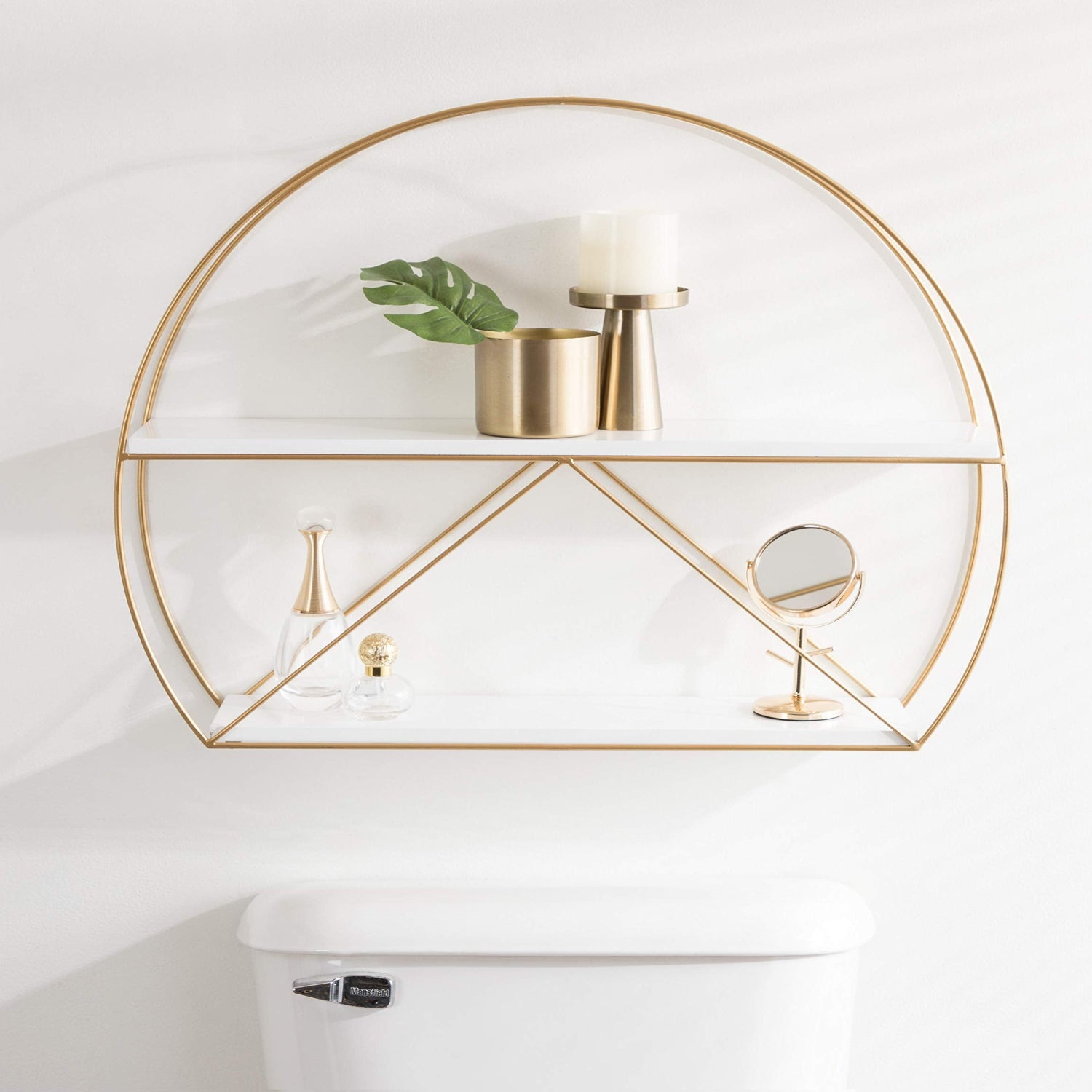 Gold geometric wall shelf with decorative items on a white wall