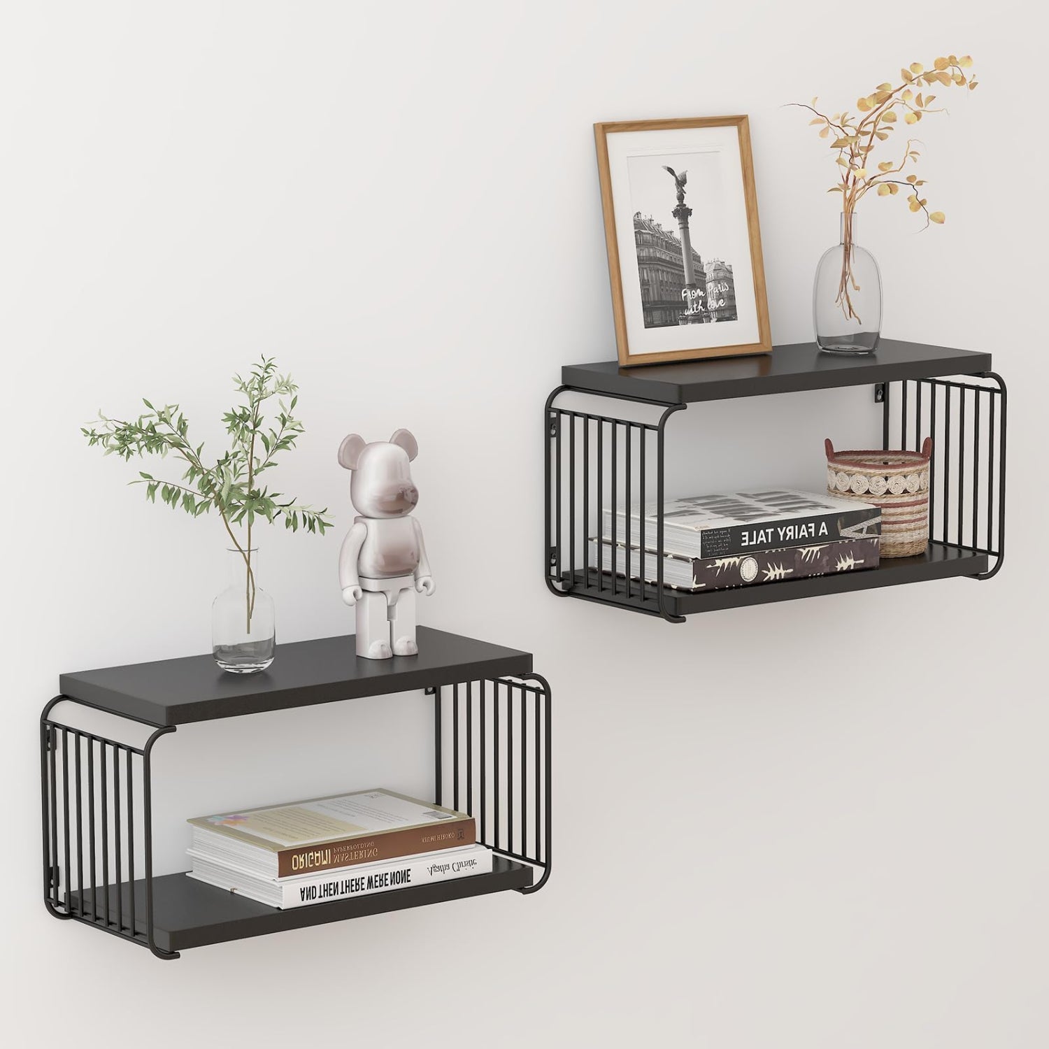 Two black metal wall shelves with books, a plant, and decorative items on a white wall.
