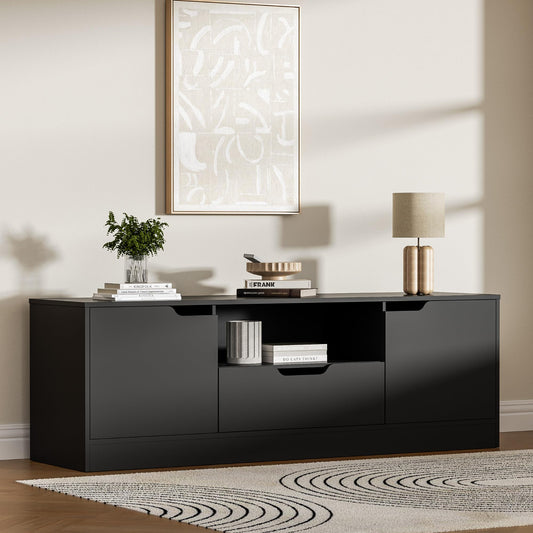 Black high-gloss entertainment console with decor items in a living room setting.