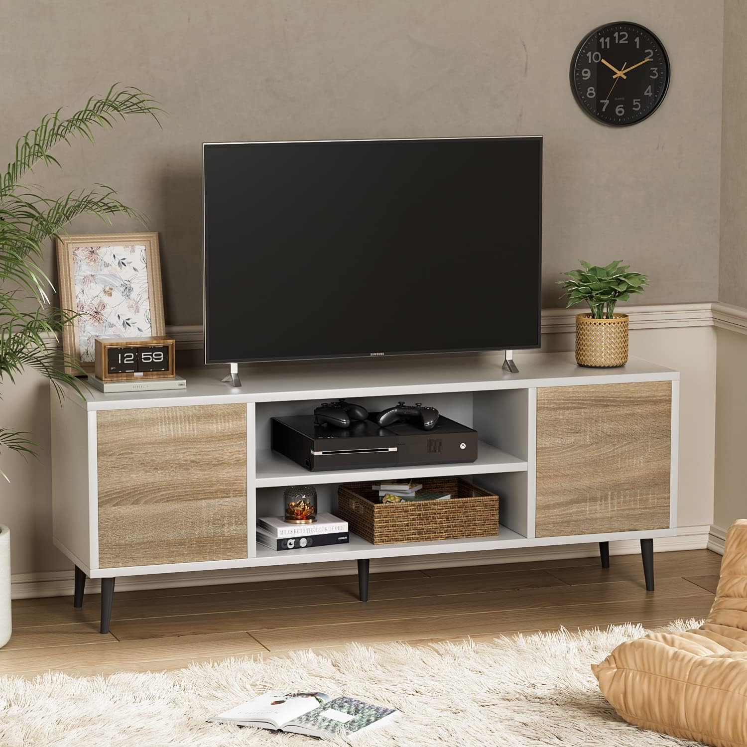 TV stand with a television, gaming console, and decorative items in a living room setting.