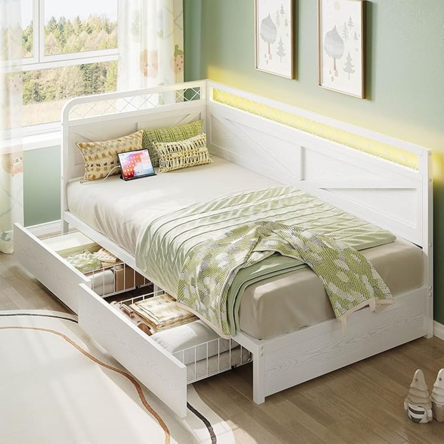 White bed with storage drawers in a room with green walls and a window.