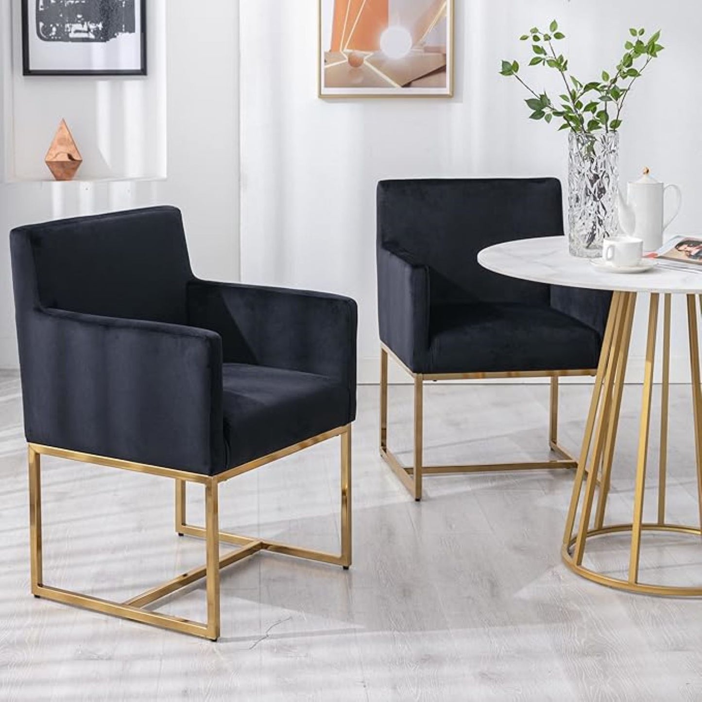 Two black chairs with gold frames in a modern room setting.