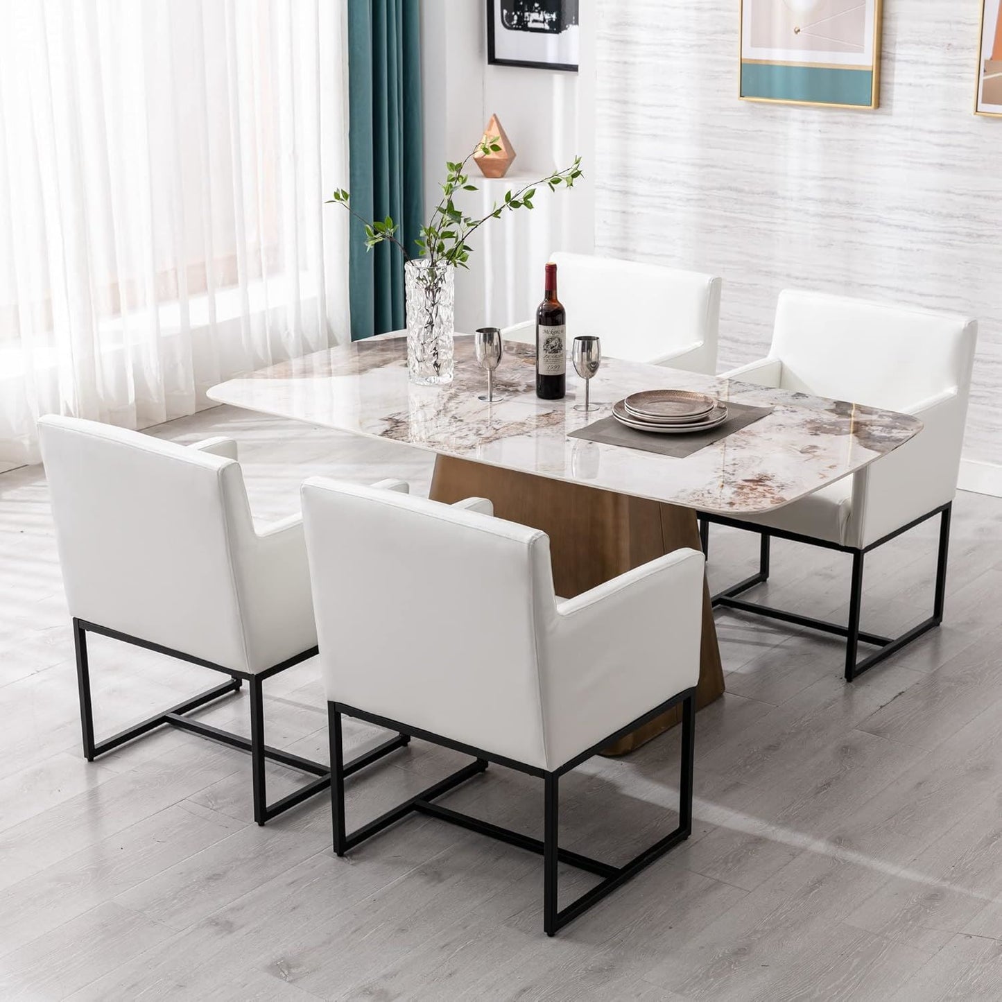 Dining room with marble table and white chairs, wine bottle and glasses on the table.