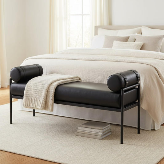 Black leather bench in front of a bed with white bedding in a bedroom setting.