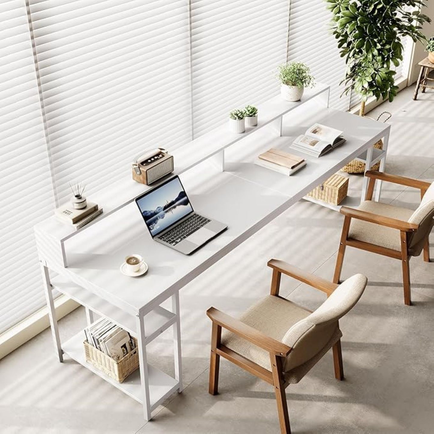 Modern home office with a white desk, laptop, and wooden chairs.