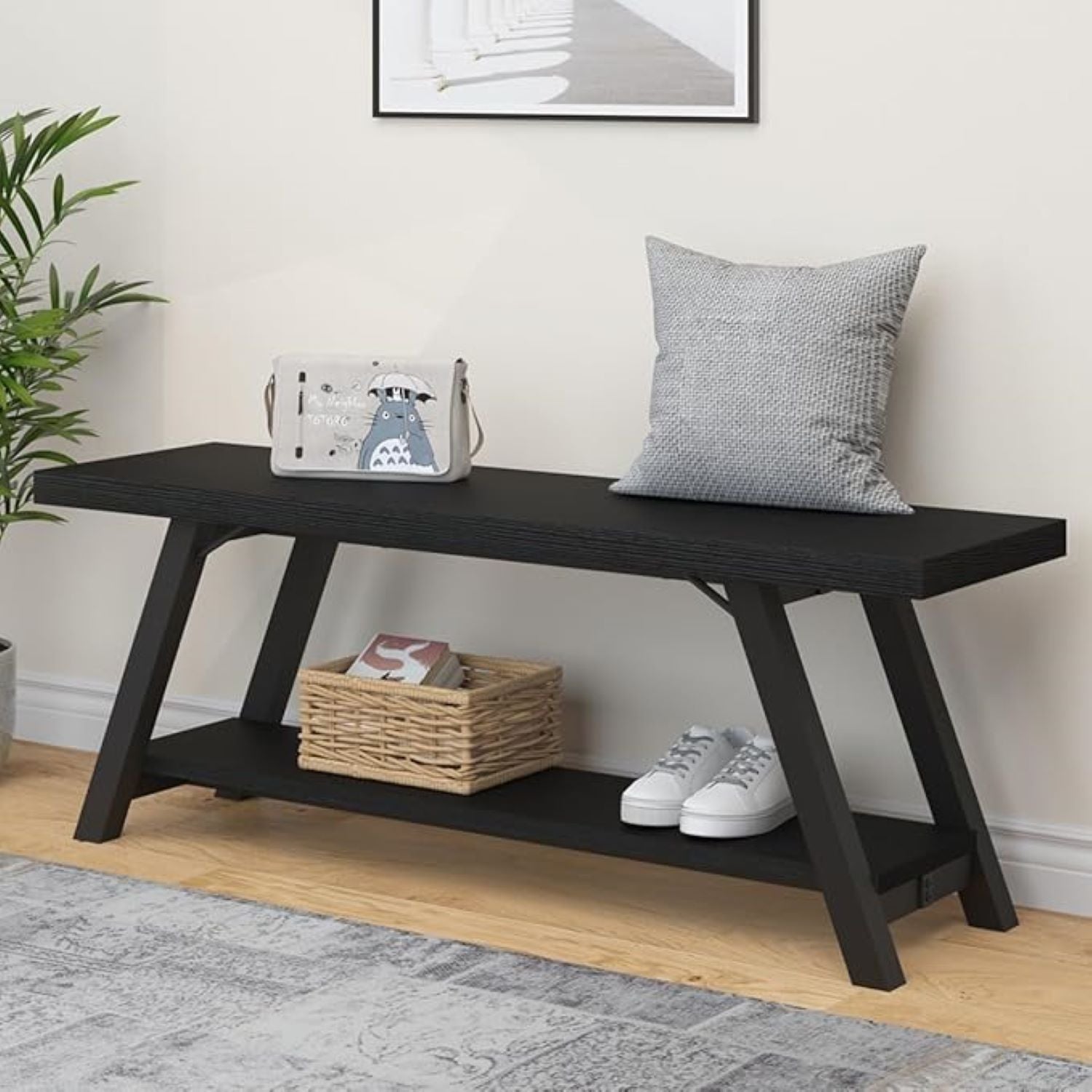 Black wooden bench with a cushion, basket, and shoes in a room setting.