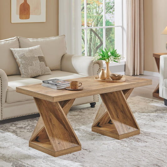 Wooden coffee table in a living room setting with a couch and decorative items.