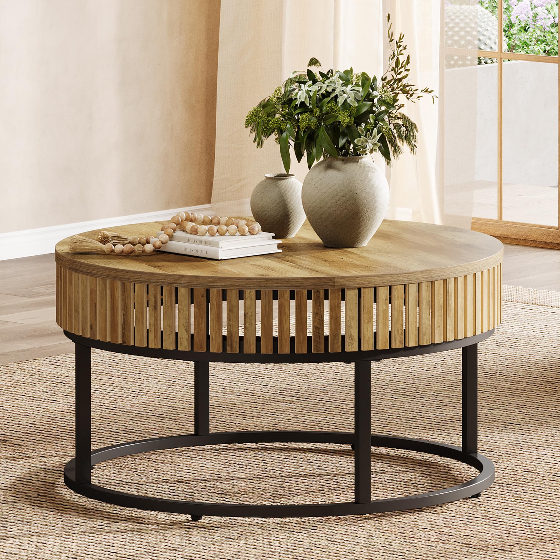 Round wooden coffee table with decorative items in a living room setting