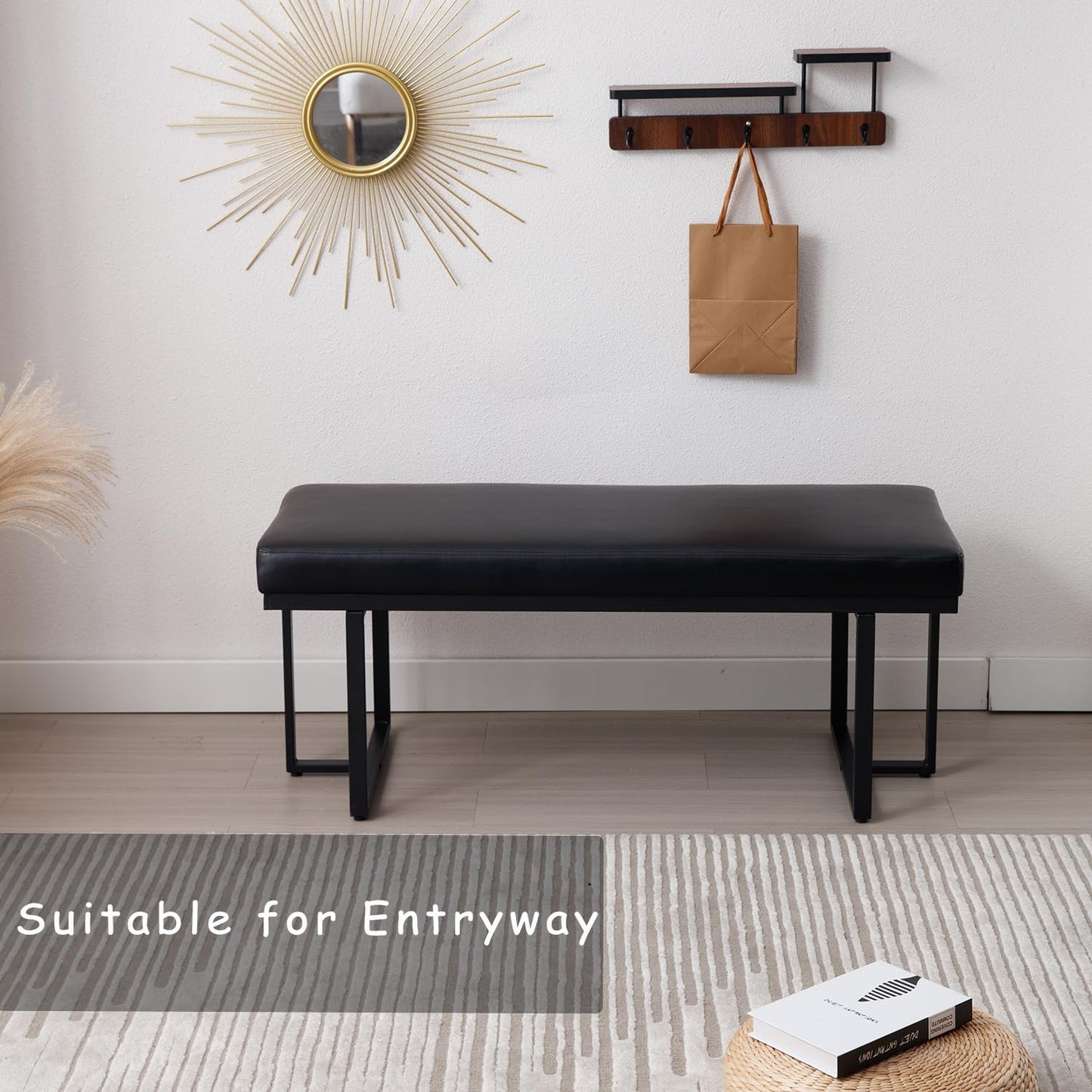 Black bench in a room with a mirror, coat rack, and rug.