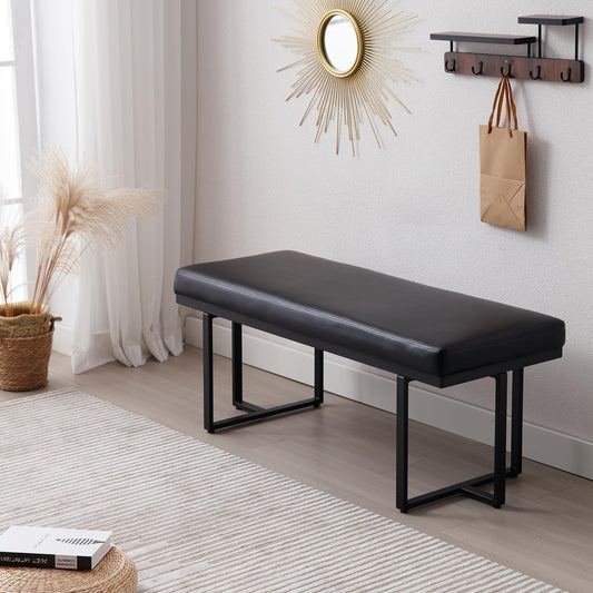 Black bench in a room with a mirror, hooks, and decor items.