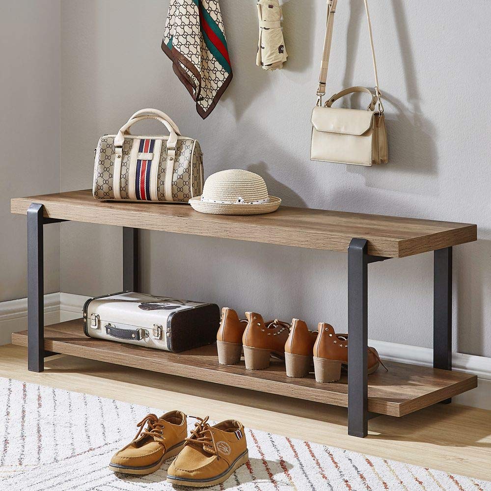 Wooden bench with bags, shoes, and a suitcase on a carpeted floor.