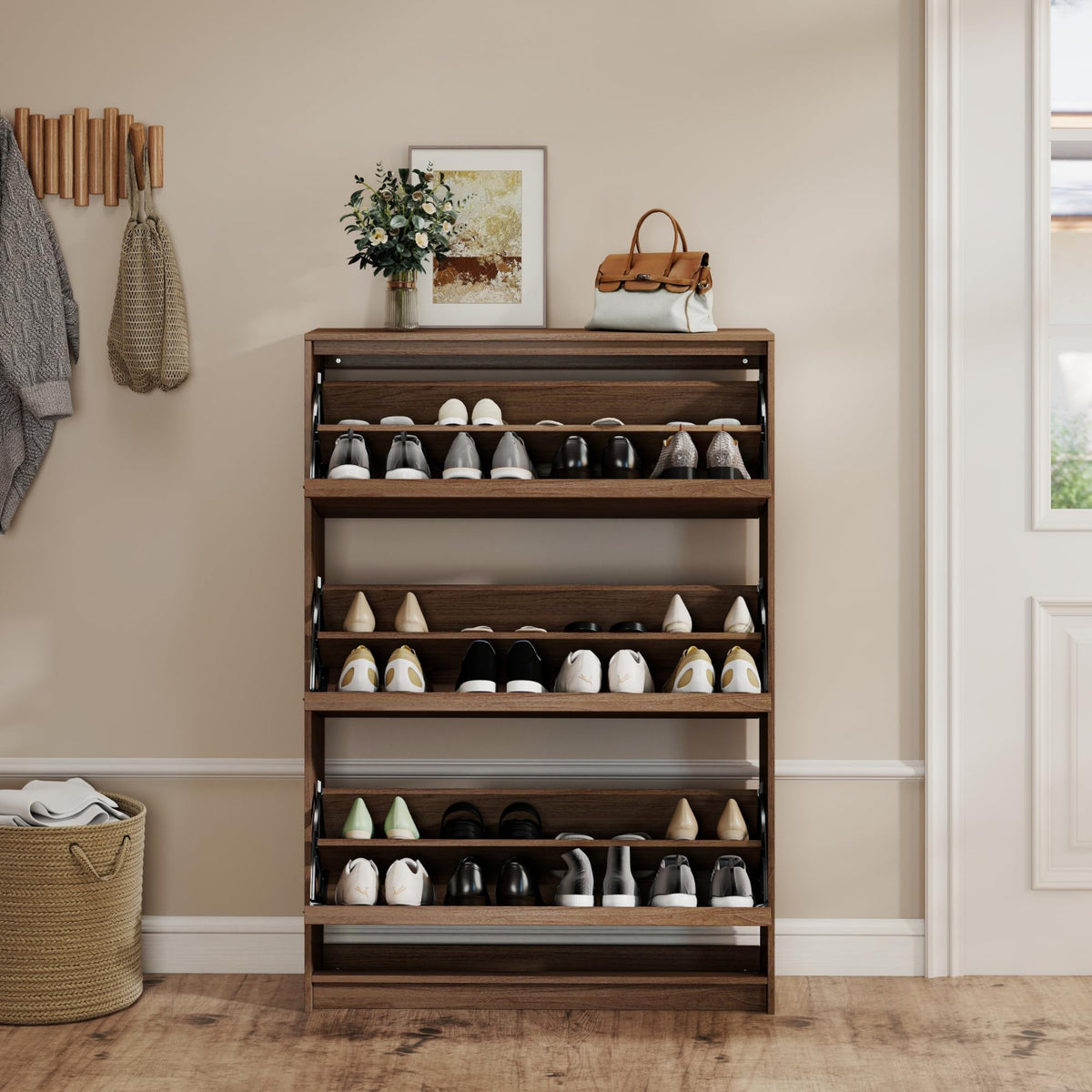 A tall wooden shoe rack with multiple shelves, styled in a home entryway with shoes, a vase of flowers, a handbag, and a coat rack on a beige wall.