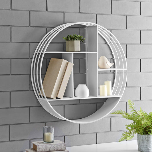 Round white wall shelf with decorative items against a gray brick wall.